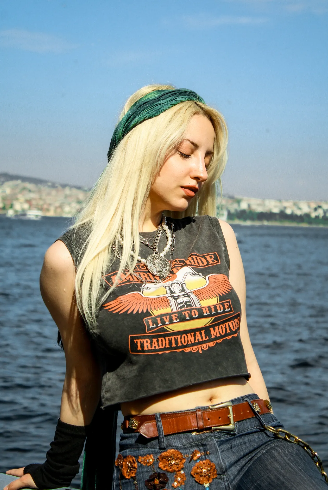 Woman in jeans with a belt by the water